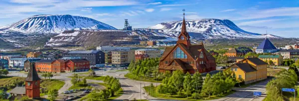 Kiruna, Sweden, with a snow-covered landscape, historic church, mining structures, and Arctic mountains