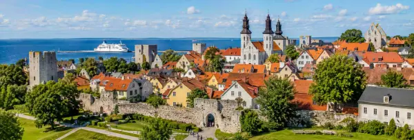 Visby, Sweden, with medieval stone walls, red-roofed houses, church ruins, and the Baltic Sea