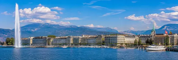 Geneva skyline and Jet d'Eau fountain overlooking Lake Geneva with mountains in Switzerland