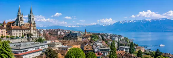Lausanne, Switzerland with its cathedral, Lake Geneva, historic rooftops, and snow-capped Alps