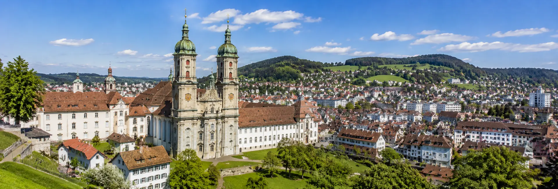 St. Gallen, Switzerland with its historic Abbey Cathedral, rooftops, and green surrounding hills