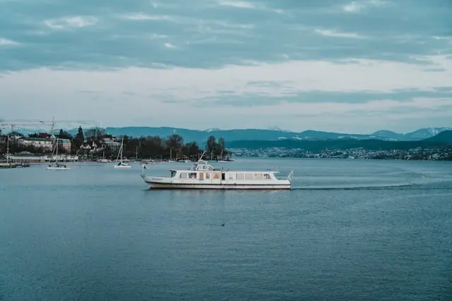 Boat cruising on Lake Zurich with Swiss Alps in the distance