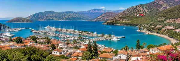 Fethiye Bay, marina, red-tiled rooftops and mountains overlooking the turquoise sea in Türkiye