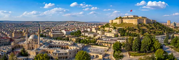 Gaziantep Castle, historic mosque and panoramic cityscape under a blue sky in Gaziantep, Turkiye