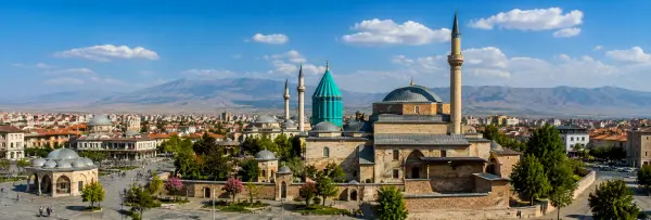 Mevlana Museum and historic cityscape with mountains in the background in Konya, Turkiye
