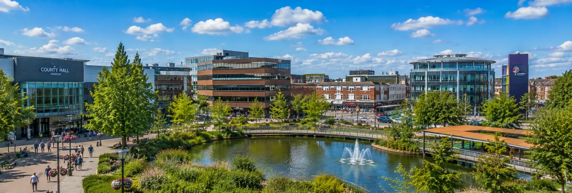Crawley, United Kingdom town centre with County Mall, fountain plaza, modern buildings and greenery