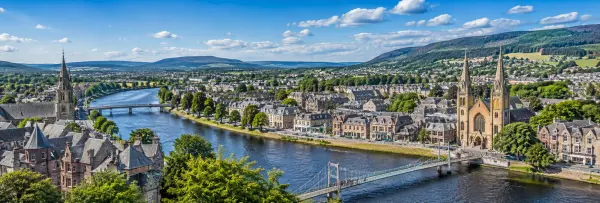 Inverness, United Kingdom cityscape with the River Ness, historic buildings and Highland hills