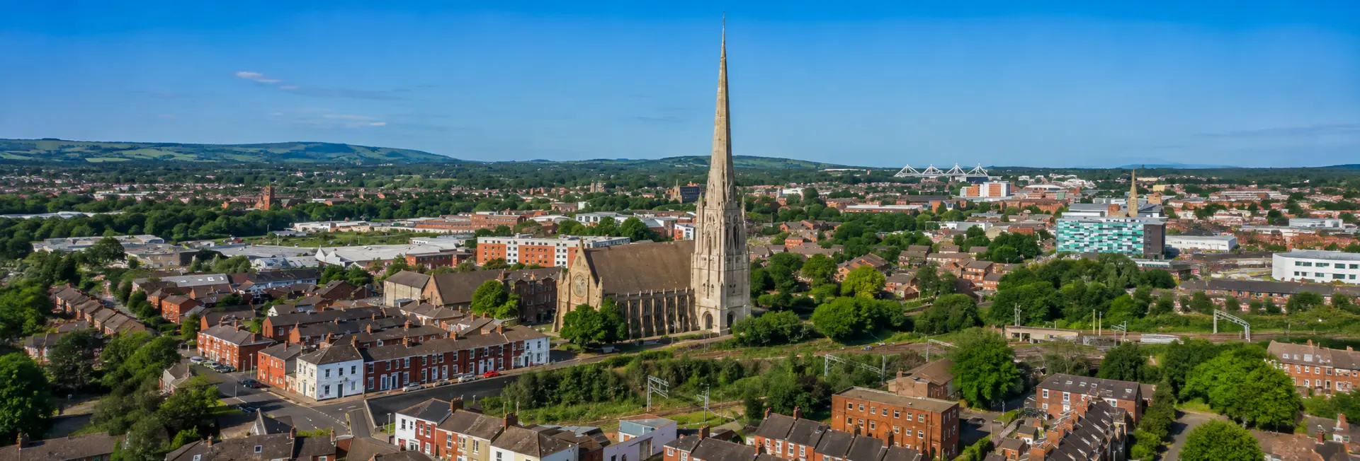 Aerial panoramic view of Preston, United Kingdom, featuring St Walburge’s Church and its tall Gothic spire