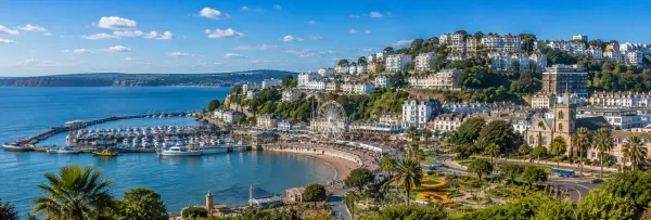 Torquay, United Kingdom seaside cityscape with marina, beach, promenade and coastal hills